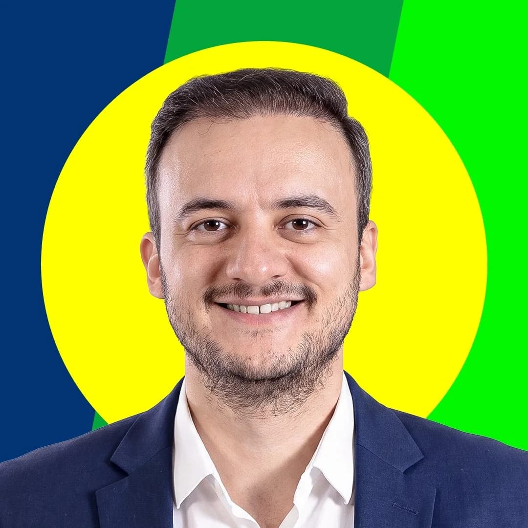 Marcos Adriano sorrindo com terno azul-marinho